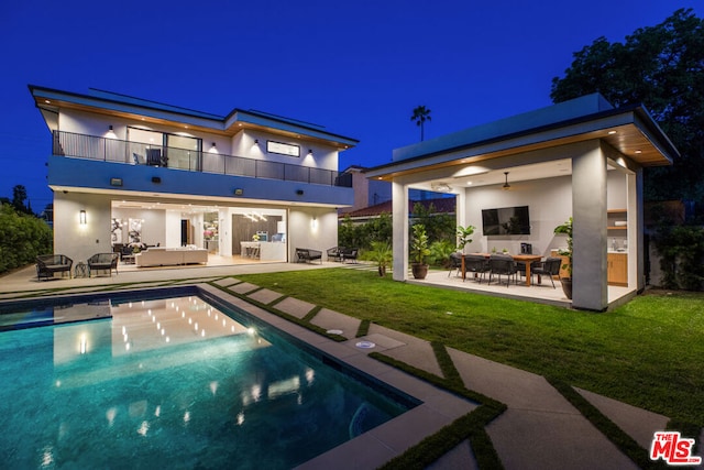 back of property featuring a lawn, an outdoor living space, a balcony, and a patio