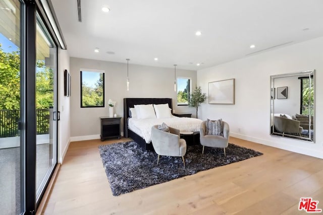 bedroom with access to exterior, light wood-type flooring, and multiple windows