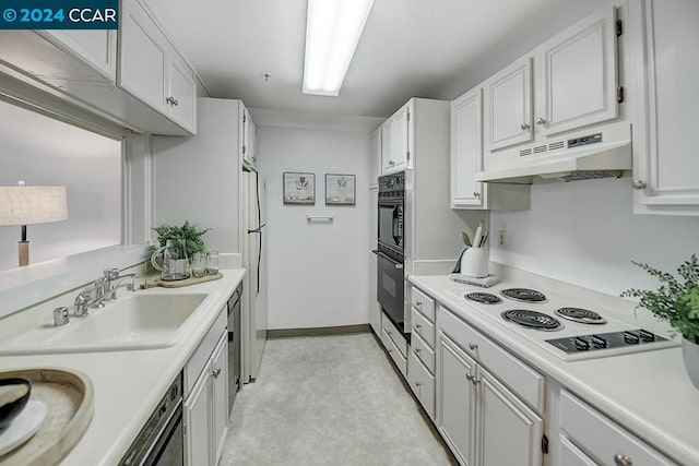 kitchen with premium range hood, white cabinetry, and sink