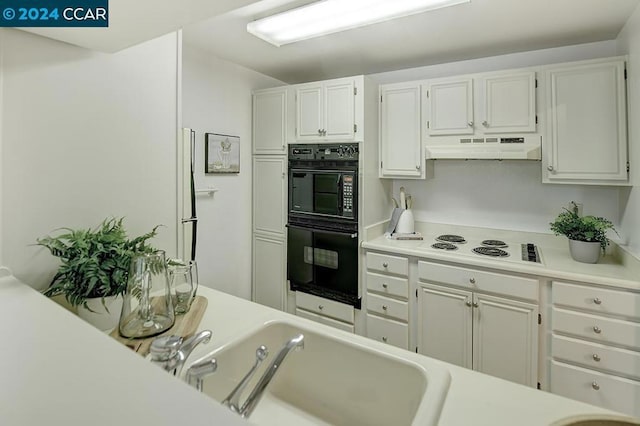 kitchen with white electric cooktop, black double oven, and white cabinets