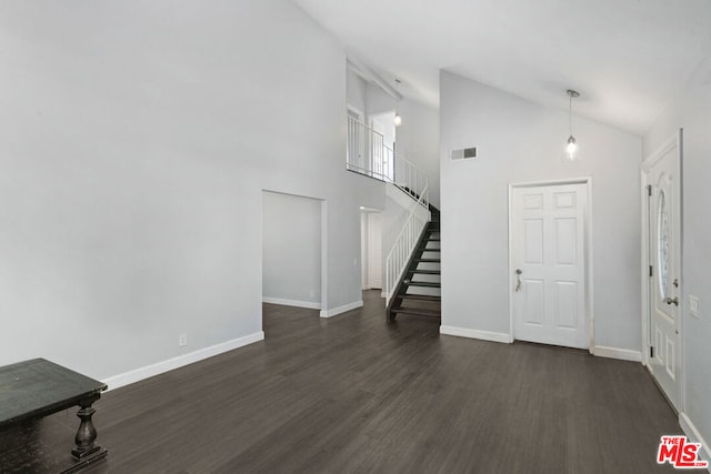 foyer with dark hardwood / wood-style flooring and high vaulted ceiling