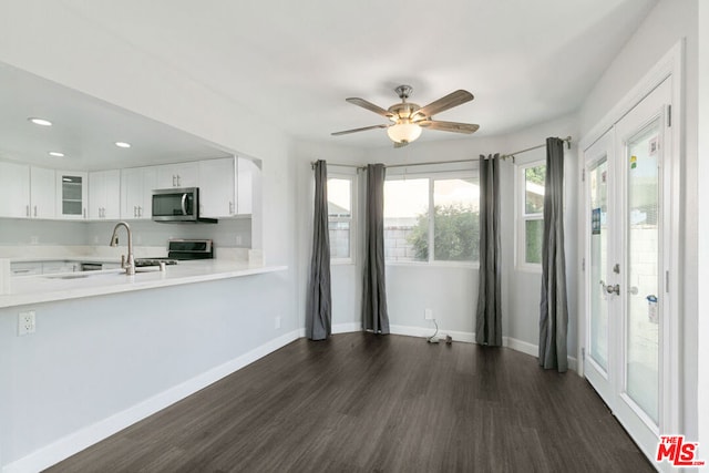 kitchen featuring kitchen peninsula, ceiling fan, dark hardwood / wood-style flooring, white cabinetry, and stainless steel appliances