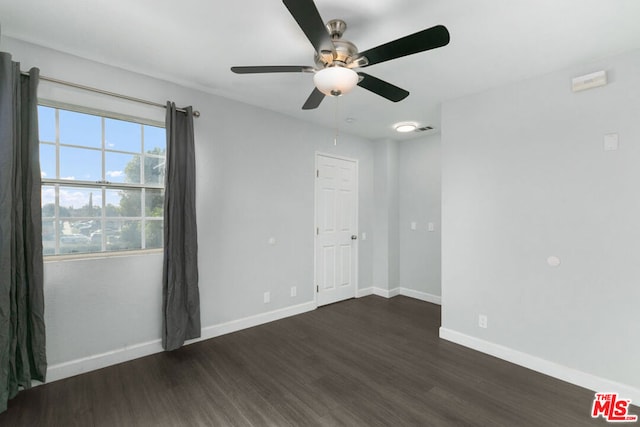 empty room featuring ceiling fan and dark hardwood / wood-style flooring