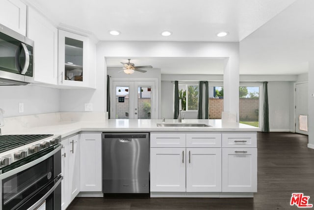 kitchen featuring sink, stainless steel appliances, dark hardwood / wood-style flooring, kitchen peninsula, and white cabinets