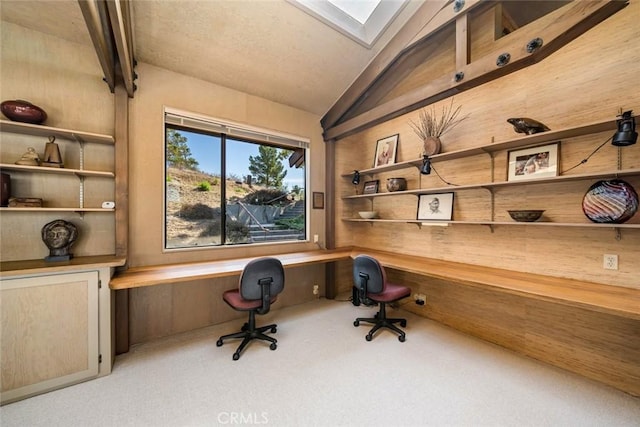 carpeted office space with built in desk and lofted ceiling