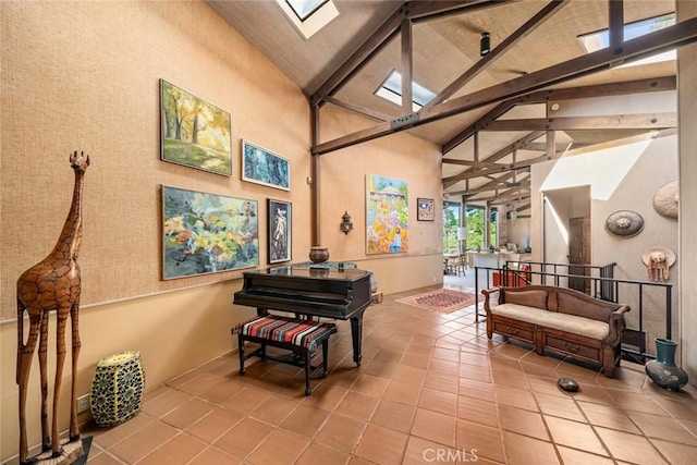 misc room with beam ceiling, light tile patterned floors, high vaulted ceiling, and a skylight