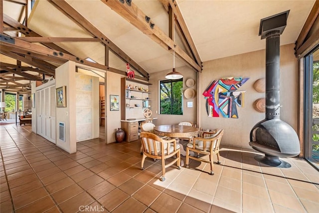 tiled dining area with vaulted ceiling with beams