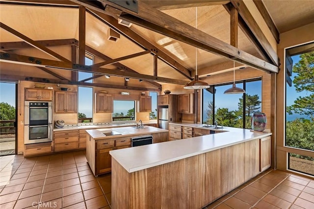 kitchen featuring stainless steel appliances, vaulted ceiling with beams, a spacious island, pendant lighting, and light tile patterned floors