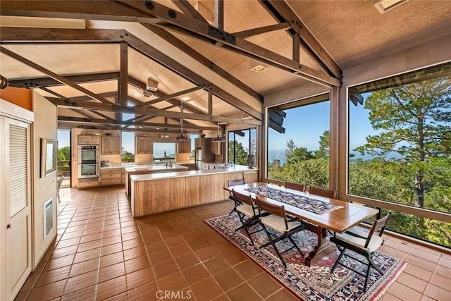 sunroom / solarium featuring vaulted ceiling with beams