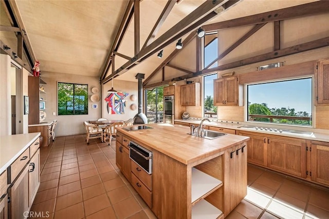 kitchen featuring wooden counters, lofted ceiling with beams, and plenty of natural light