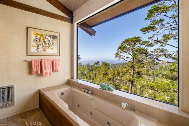 bathroom featuring tiled bath, heating unit, and vaulted ceiling