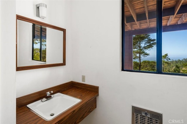 bathroom featuring beam ceiling, wood ceiling, and sink