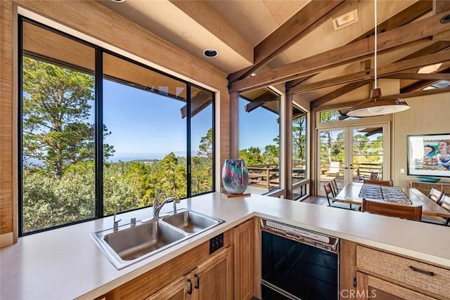 kitchen featuring dishwasher, french doors, lofted ceiling with beams, sink, and decorative light fixtures