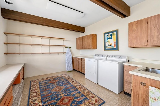 washroom with cabinets, separate washer and dryer, and sink