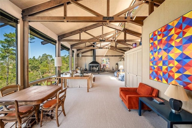 sunroom with vaulted ceiling with beams, a healthy amount of sunlight, and a wood stove