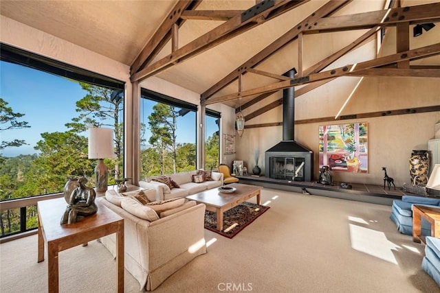 interior space with beam ceiling, high vaulted ceiling, and a wood stove