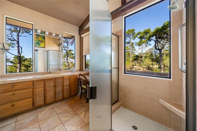 bathroom with vanity, tile patterned floors, walk in shower, and tile walls