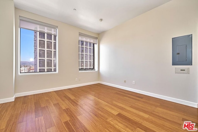 unfurnished room with hardwood / wood-style floors and electric panel