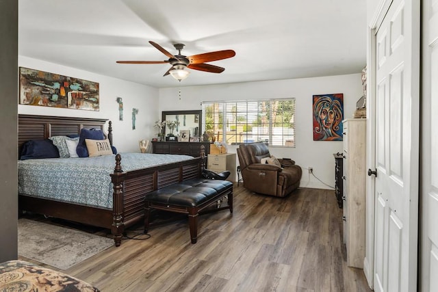 bedroom with a closet, hardwood / wood-style flooring, and ceiling fan