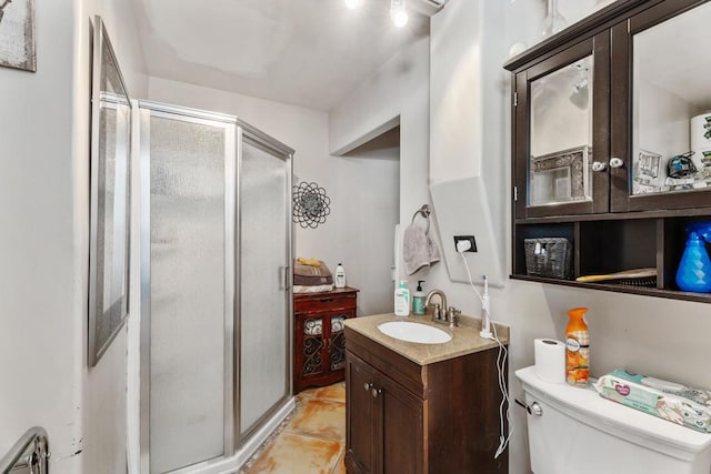 bathroom with tile patterned flooring, vanity, toilet, and an enclosed shower