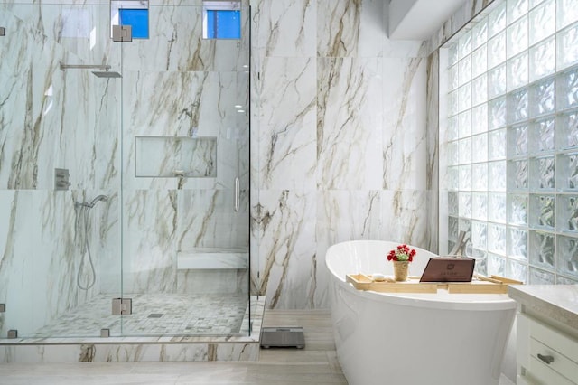 bathroom with vanity, tile walls, and shower with separate bathtub