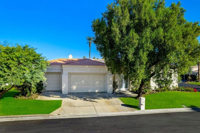 obstructed view of property featuring a garage and a front yard