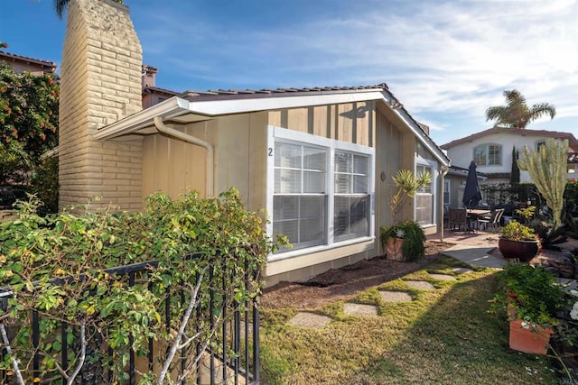 view of side of home featuring a yard and a patio