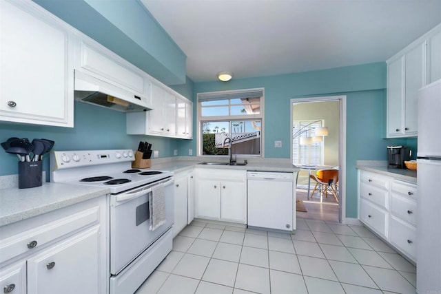 kitchen featuring white cabinets, light tile patterned flooring, white appliances, and sink