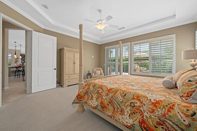 carpeted bedroom featuring a raised ceiling, ceiling fan, and ornamental molding