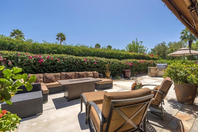 view of patio / terrace with exterior kitchen and an outdoor living space with a fire pit