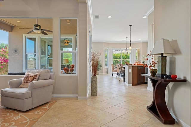 sitting room with crown molding, light tile patterned floors, and ceiling fan with notable chandelier