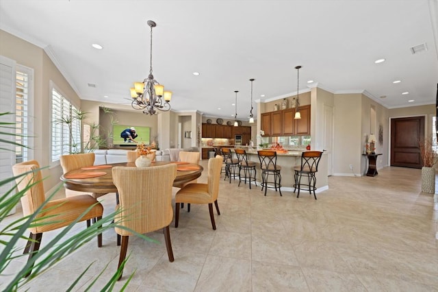 dining space with ornamental molding and a notable chandelier