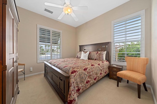 bedroom with ceiling fan, light carpet, and a closet