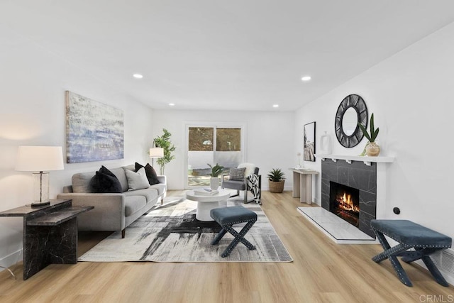 living room featuring a premium fireplace and light hardwood / wood-style flooring