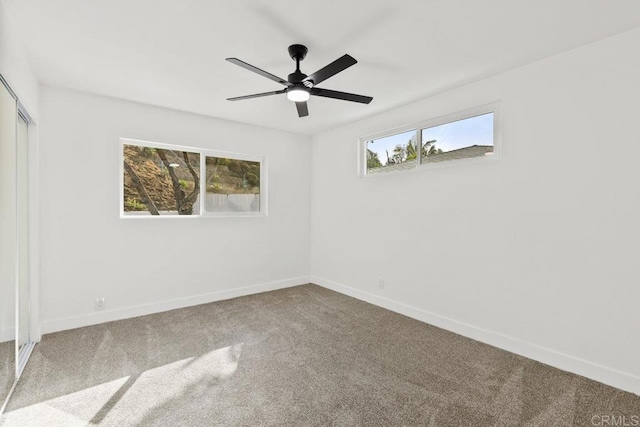 carpeted spare room with ceiling fan