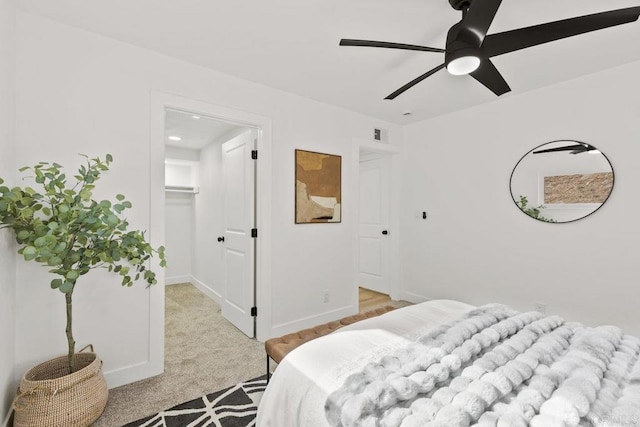 carpeted bedroom with ceiling fan, a spacious closet, and a closet