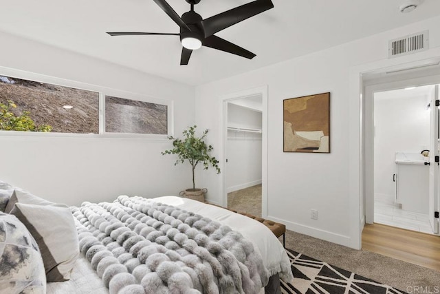 bedroom with ceiling fan, a spacious closet, carpet, and a closet