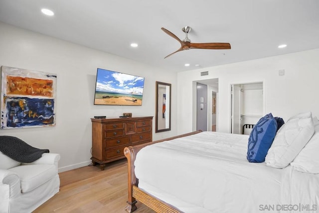 bedroom featuring ceiling fan, light hardwood / wood-style floors, a spacious closet, and a closet