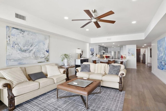 living room featuring ceiling fan and dark hardwood / wood-style flooring