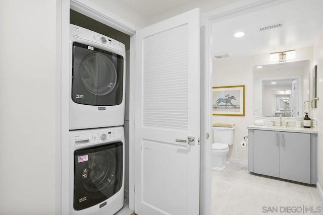 laundry room featuring stacked washer and clothes dryer and sink