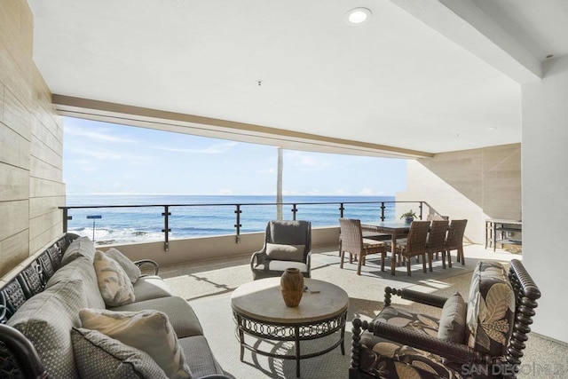 interior space featuring a water view, outdoor lounge area, and a balcony