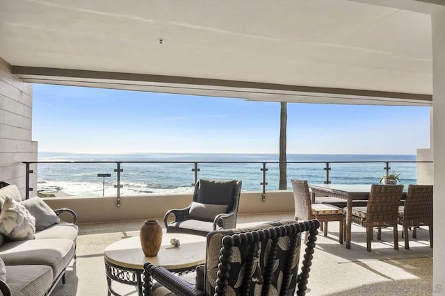 balcony with a water view, an outdoor hangout area, and a view of the beach