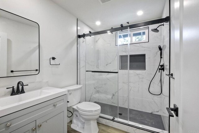 bathroom featuring vanity, toilet, and walk in shower