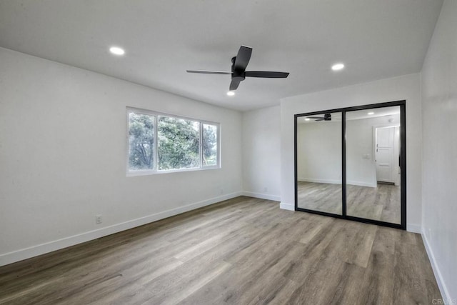 unfurnished bedroom featuring light hardwood / wood-style floors, a closet, and ceiling fan