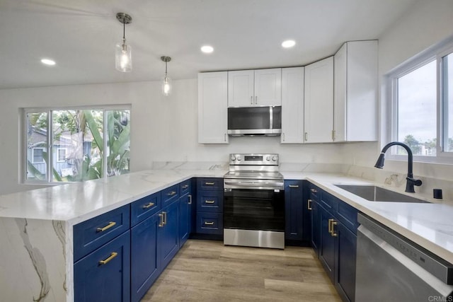 kitchen featuring blue cabinetry, kitchen peninsula, white cabinetry, and stainless steel appliances