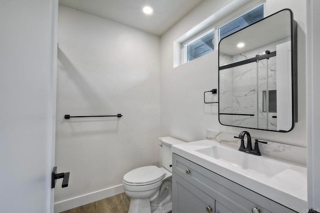 bathroom with toilet, an enclosed shower, hardwood / wood-style flooring, and vanity