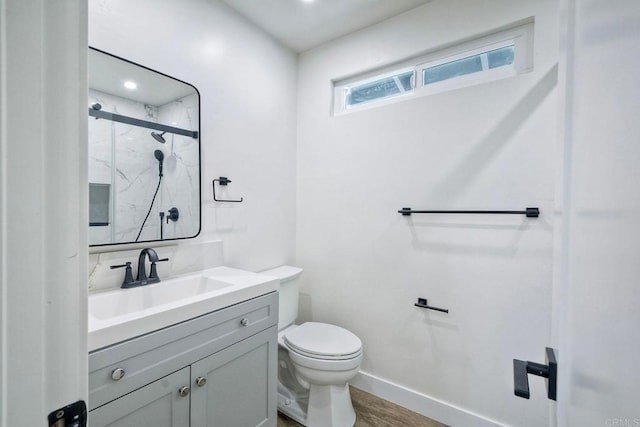 bathroom featuring vanity, a shower with shower door, wood-type flooring, and toilet