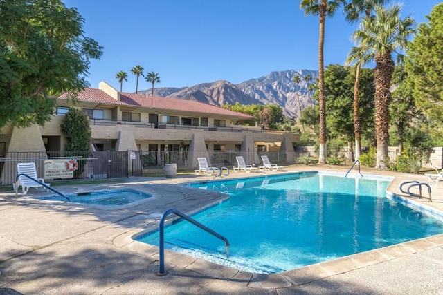 view of pool with a patio area, a mountain view, and a hot tub