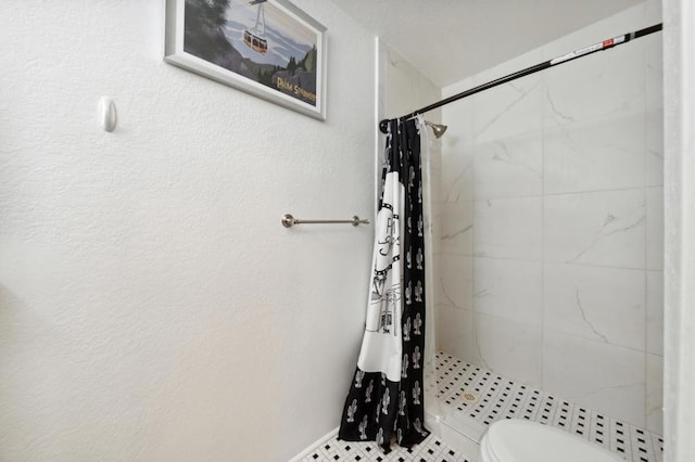 bathroom featuring curtained shower, tile patterned flooring, and toilet