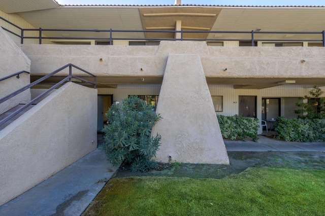 entrance to property with a lawn and a balcony